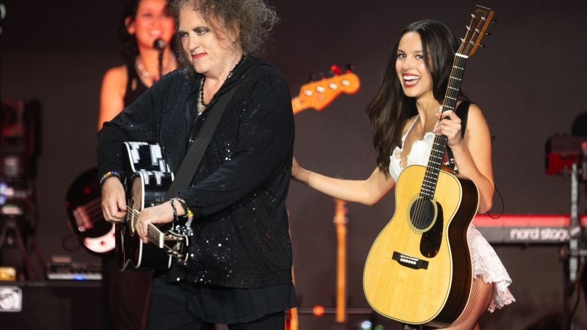 Músicos de bandas dos anos 90 exibem estilo marcante com roupas pretas brilhantes e vestido branco rendado, clima vibrante e