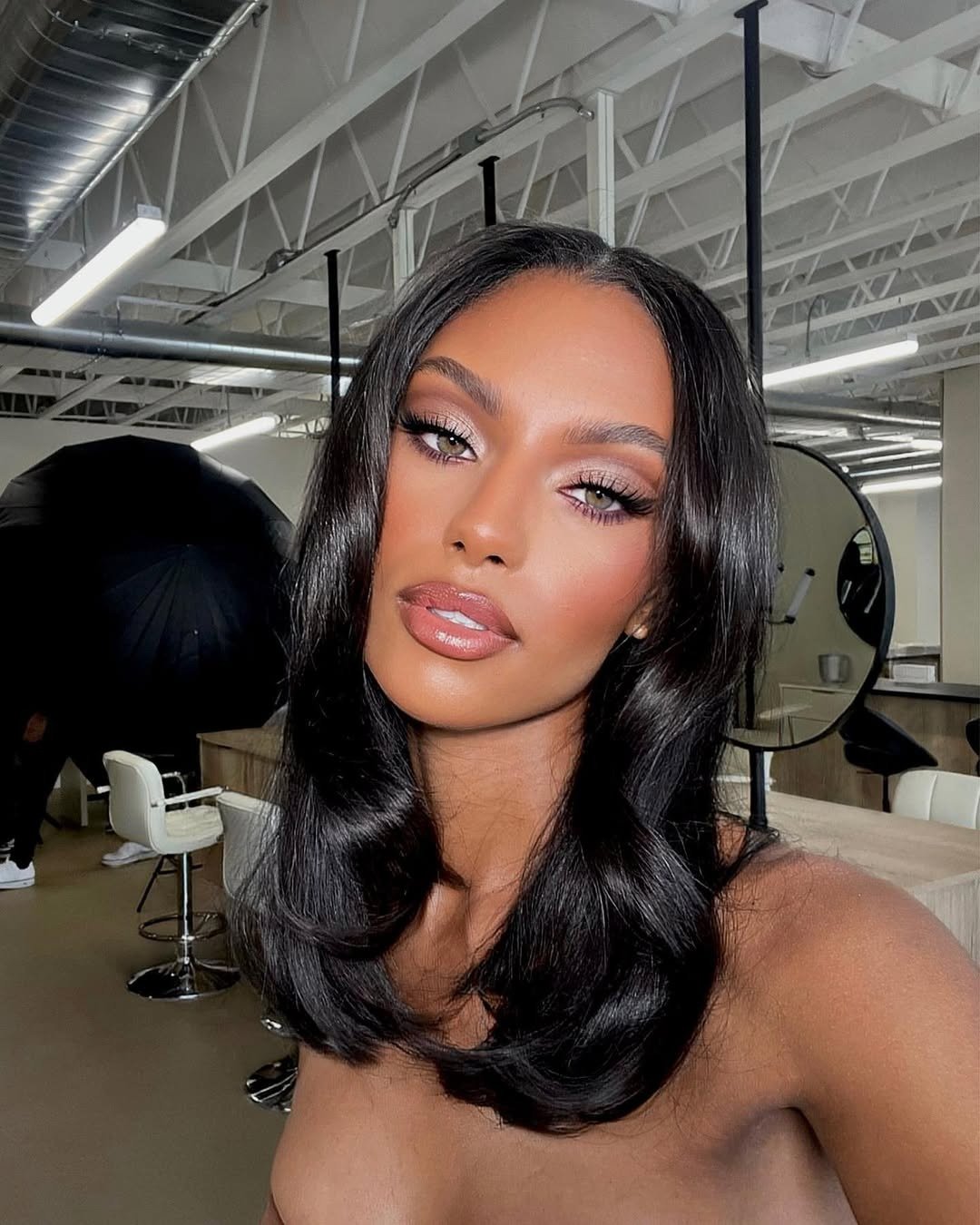 Modelo posa com corte de cabelo 2026 médio, em ondas suaves e brilho natural, destacando elegância e sofisticação no salão