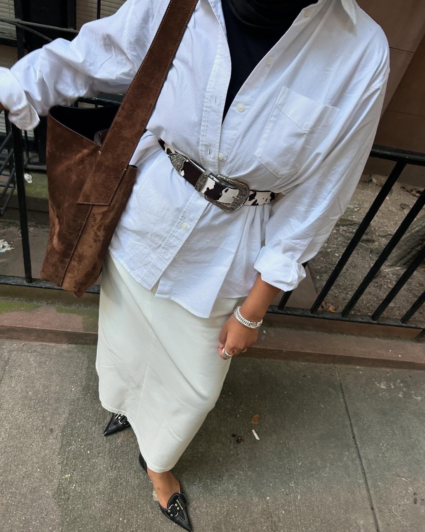 Como usar cinto com camisa branca oversized e saia midi off-white, destacando cinto animal print e bolsa marrom em look