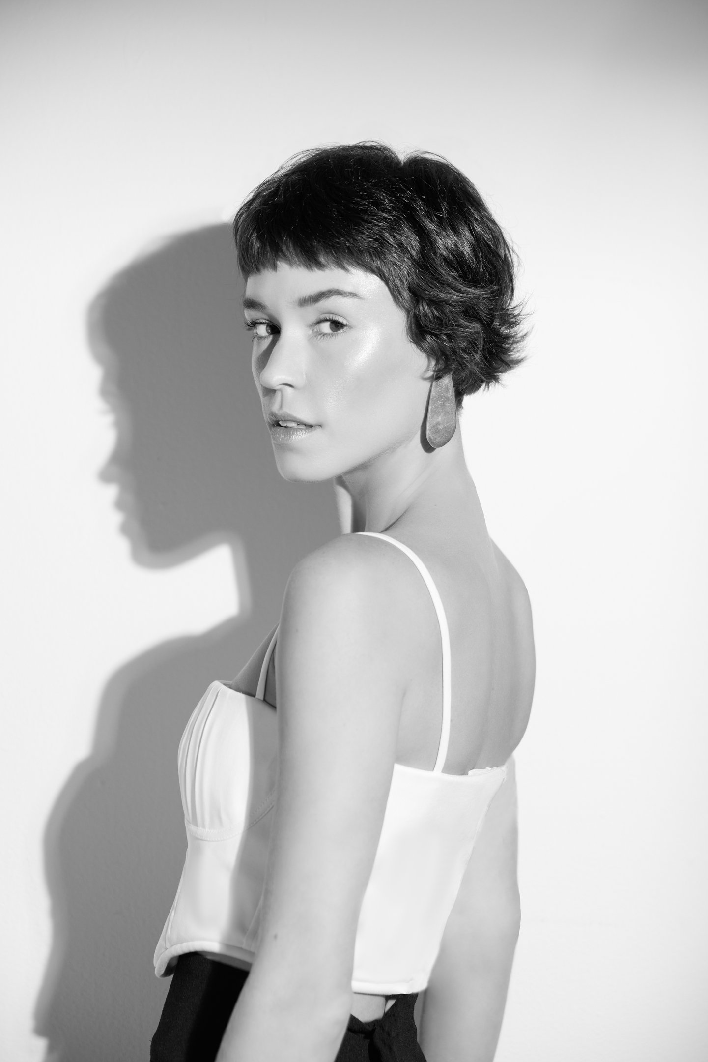 Modelo posa com cortes de cabelo da moda em estilo curto e repicado, destacando textura natural e look sofisticado em preto