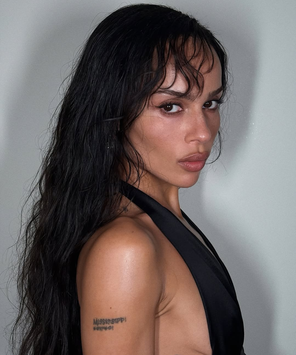 Corte de cabelo das celebridades com fios longos, textura natural e franja desfiada, realçando olhar intenso.