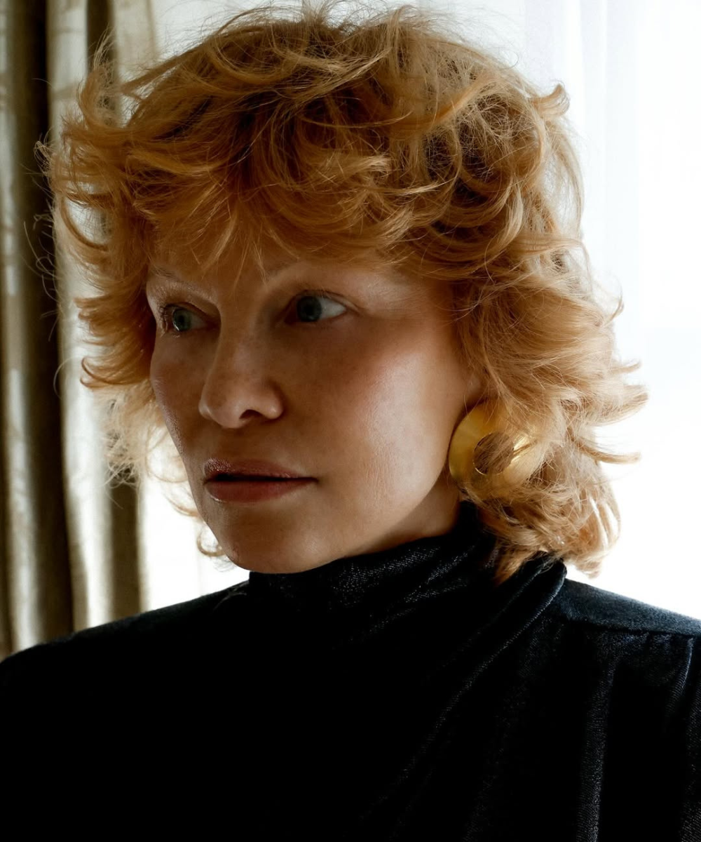 Mulher posa com cortes de cabelo das celebridades em estilo shag ondulado ruivo, combinando maxi brinco dourado.