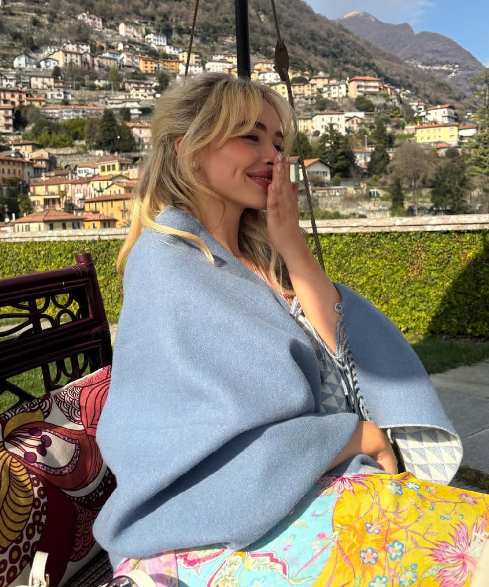 Corte de cabelo das celebridades com ondas soltas e franja, combinando loiro iluminado e estilo casual em clima descontraído.