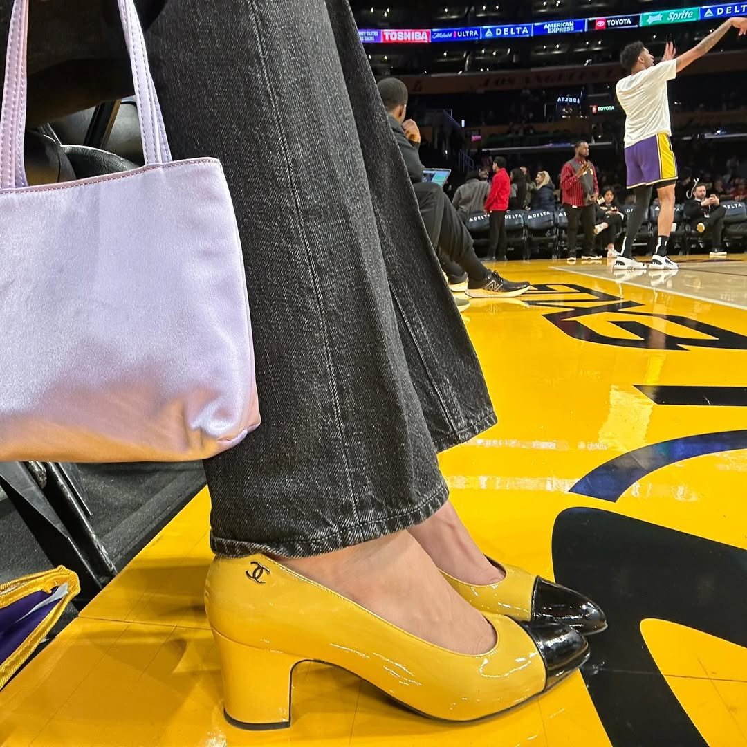 Estilo de Devon Lee Carlson destaca sapato Chanel amarelo com bico preto em verniz, jeans escuro de modelagem reta e bolsa