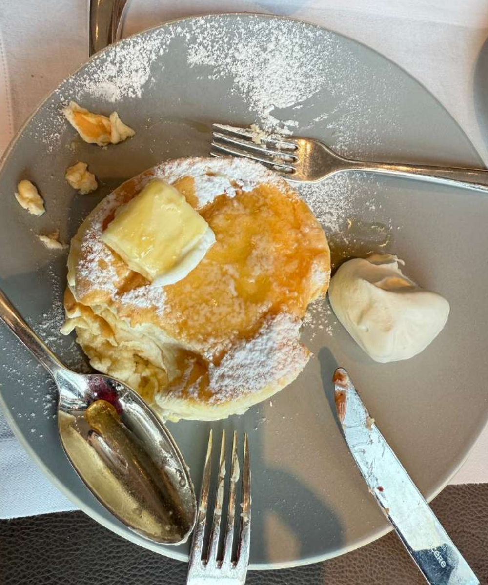 Panqueca japonesa fofa com manteiga derretida, açúcar de confeiteiro e chantilly em prato cinza, dicas de Tóquio para café da