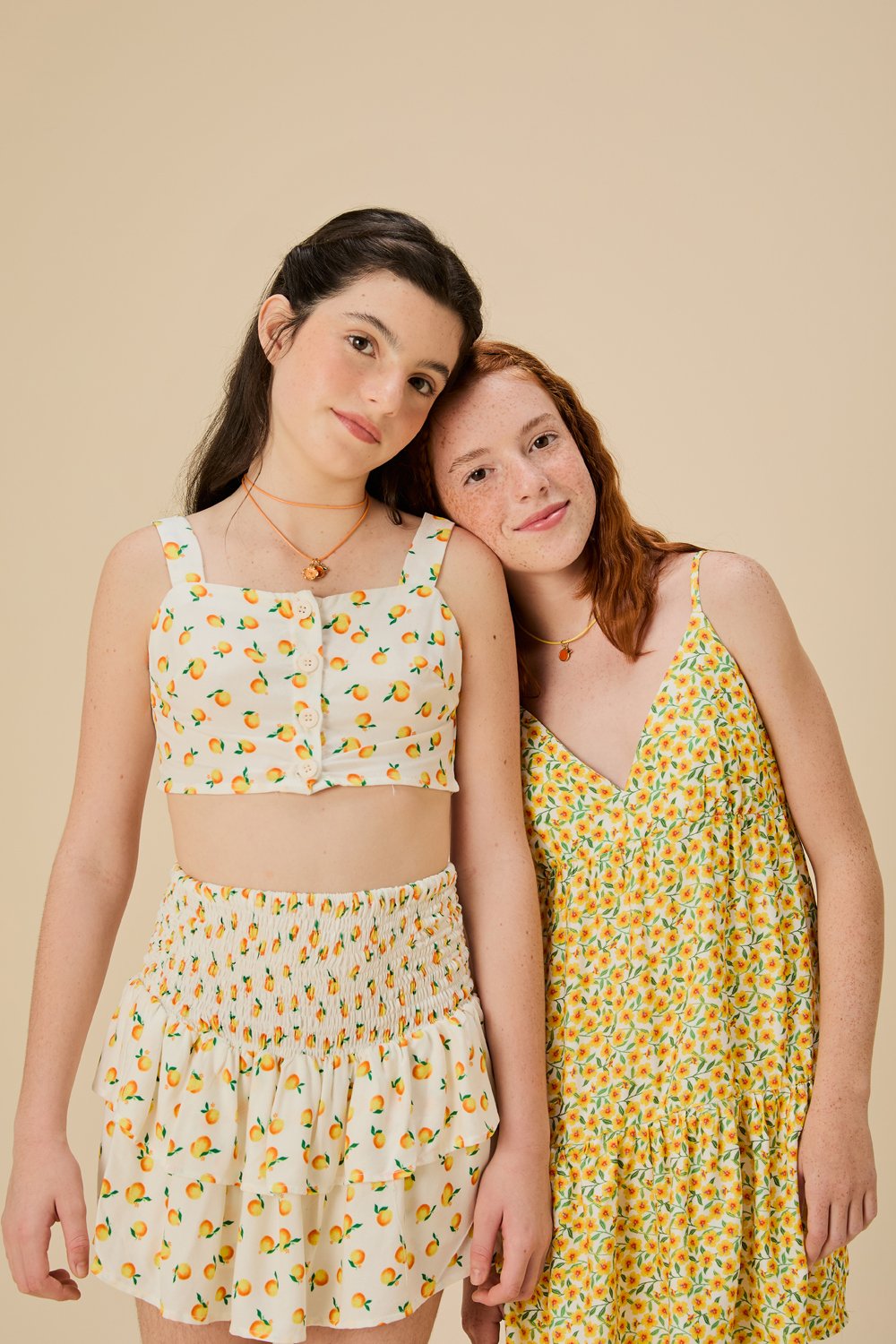 Modelos posam com peças leves FARM Futura em tons amarelo e branco, estampas florais e de frutas, transmitindo frescor e