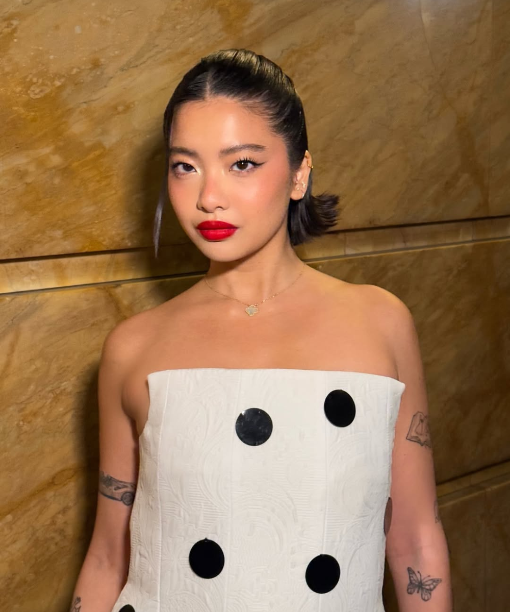 Modelo posa com ideias de maquiagem para o Natal, usando batom vermelho vibrante, delineado preto e pele iluminada.