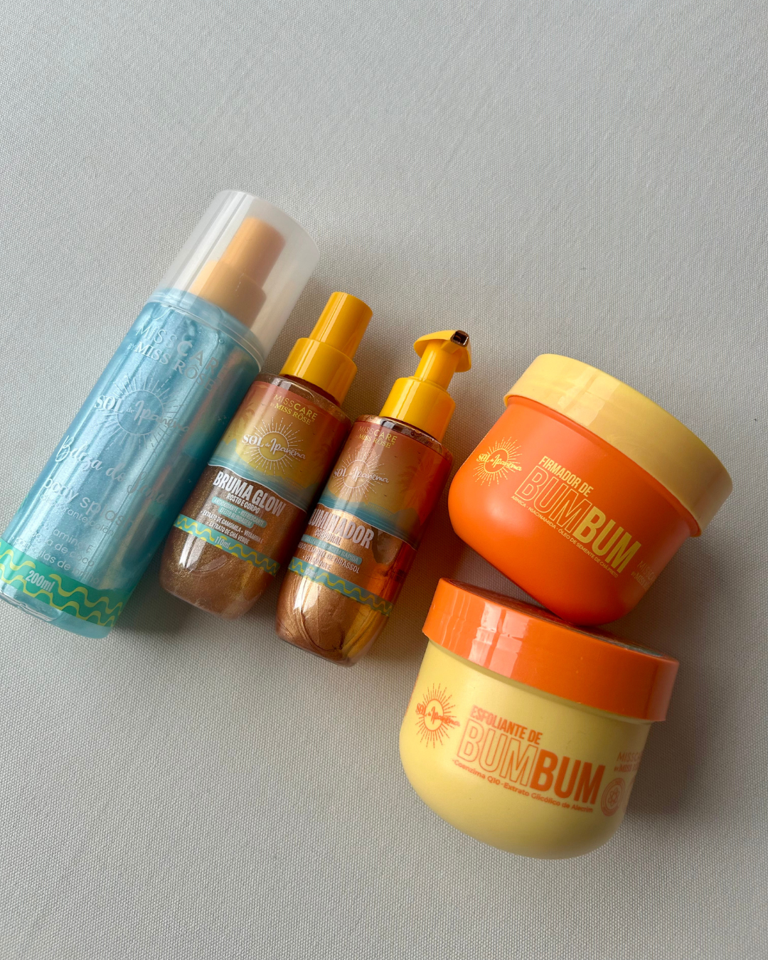 Conjunto de cosméticos com creme firmador em embalagem laranja vibrante e textura cremosa, destacando cuidados corporais