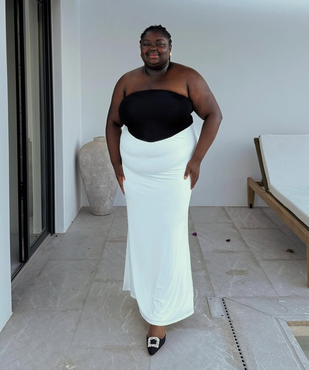 Modelo posa com vestido longo tomara que caia em preto e branco de tecido fluido, combinando elegância e conforto em looks