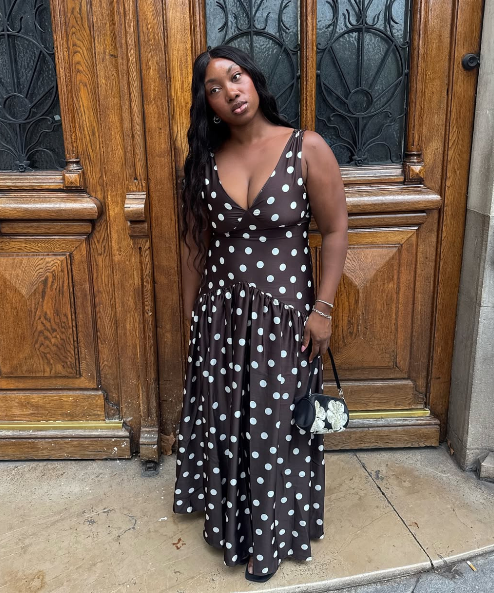 Vestido longo marrom de tecido fluido com estampa de bolinhas brancas, decote v e saia ampla, ideal para looks de férias.