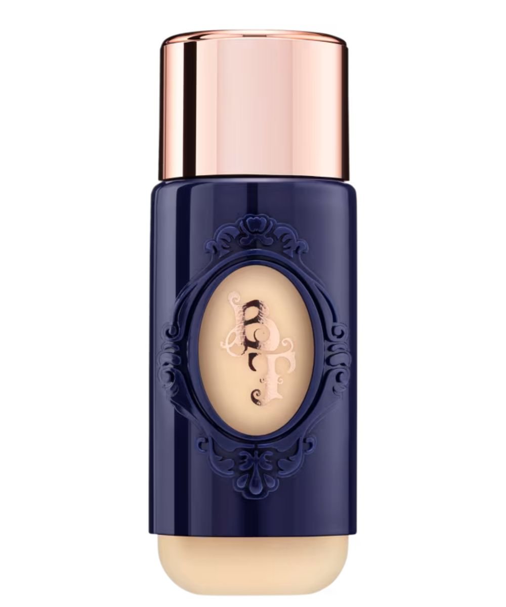 Frasco azul marinho com tampa dourada rosé destaca o melhor base para pele madura, unificando tom com textura cremosa.