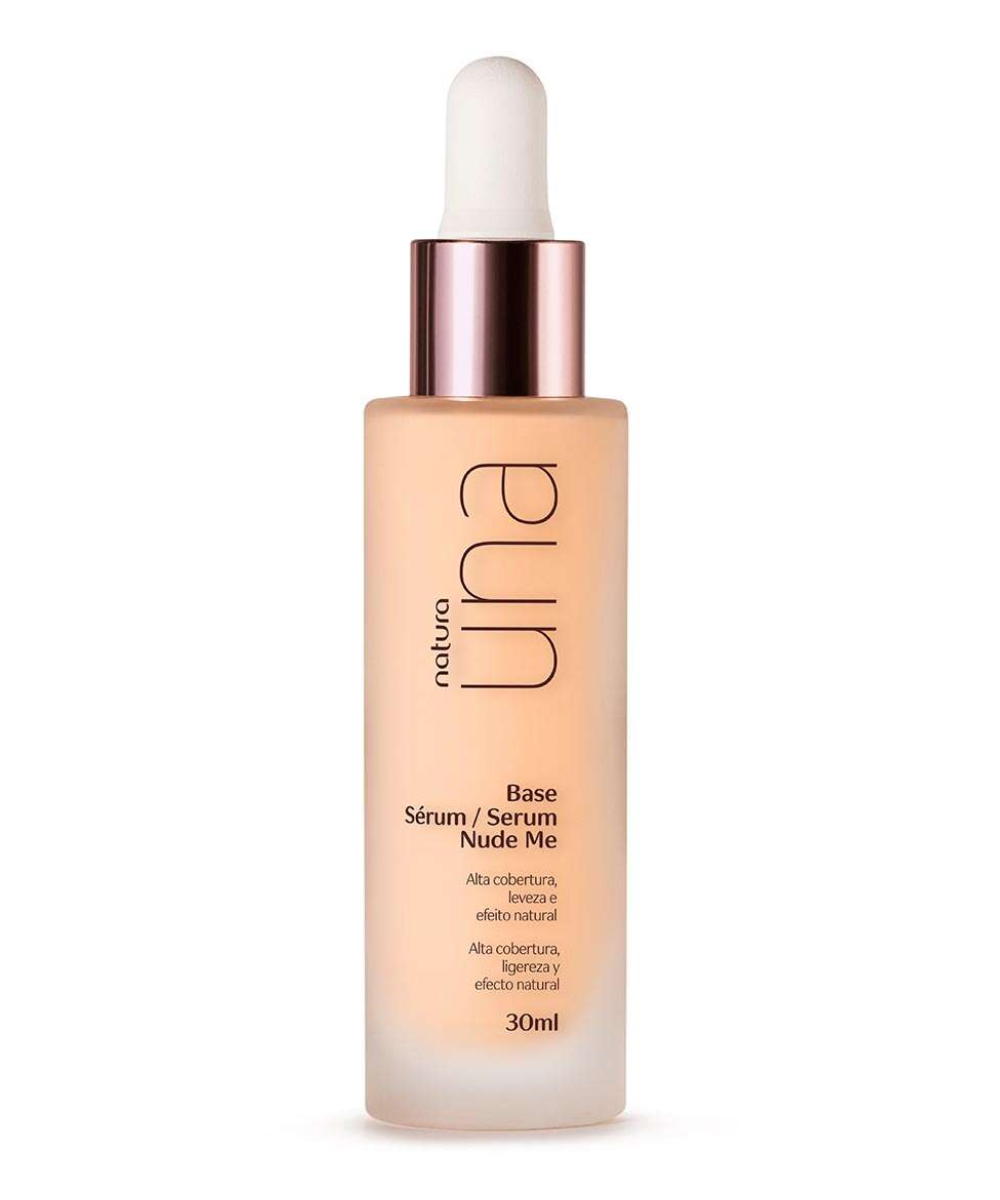 Base sérum Nude Me da Natura Una em vidro fosco com tampa metálica rosé, destaca alta cobertura e efeito natural.