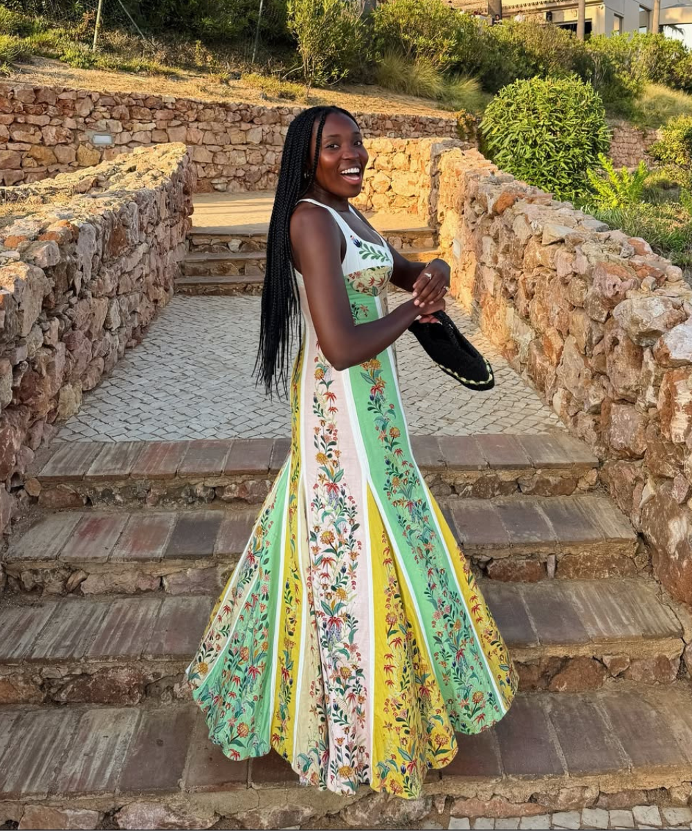 Vestido longo fluido com estampa floral em tons de verde, amarelo e branco, ideal para o que usar em um casamento na praia.