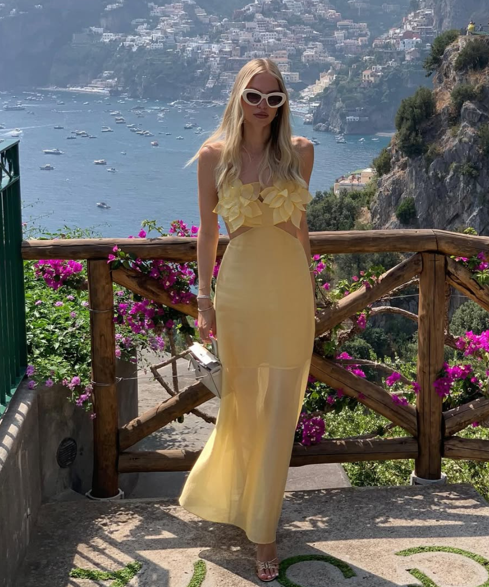 Vestido amarelo fluido com detalhes florais no busto, modelagem ajustada e tecido leve ideal para o que usar em um casamento.