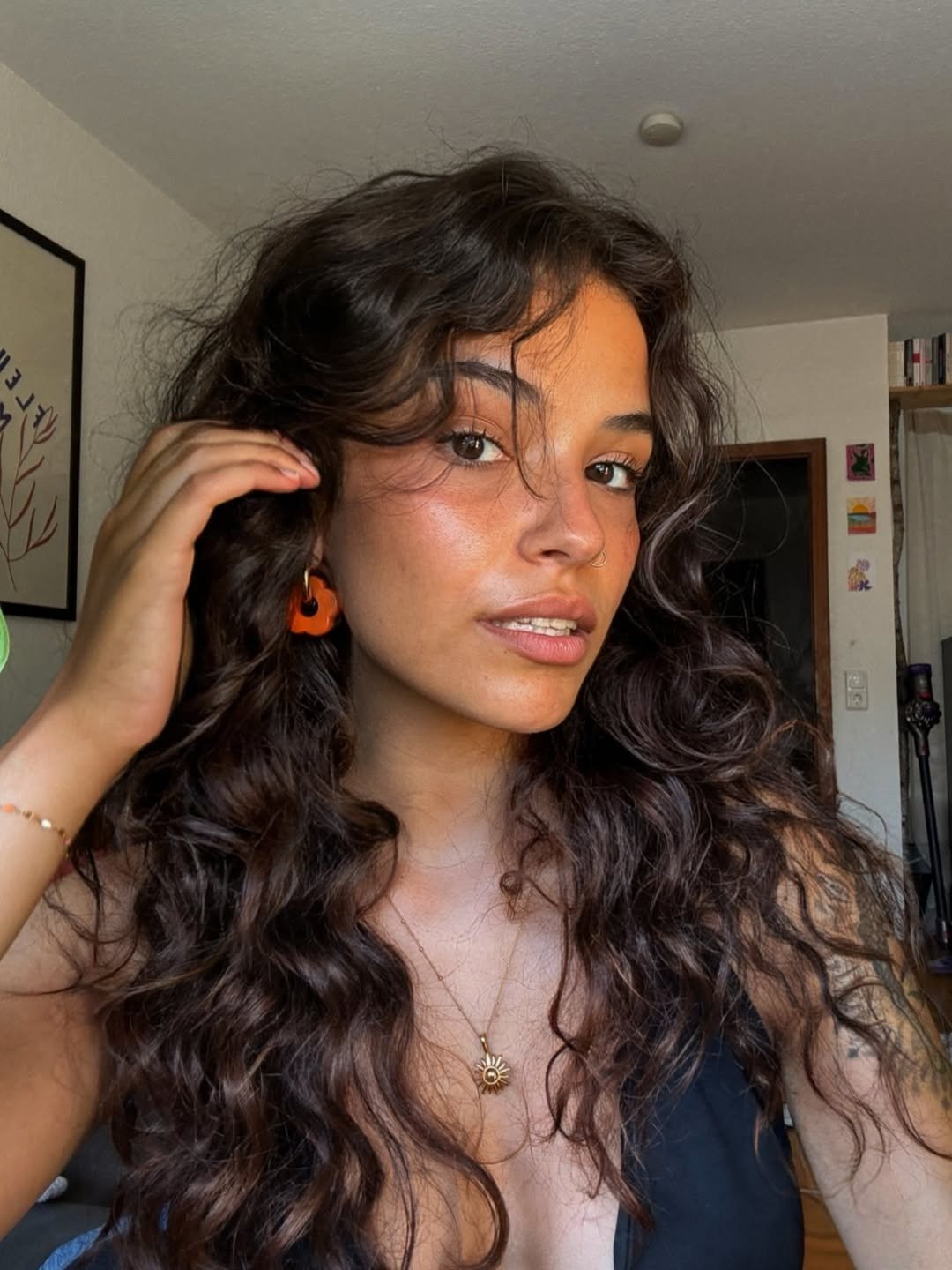 Modelo posa com cabelos longos e cacheados compele radiante e saudável usando protetor solar multifuncional