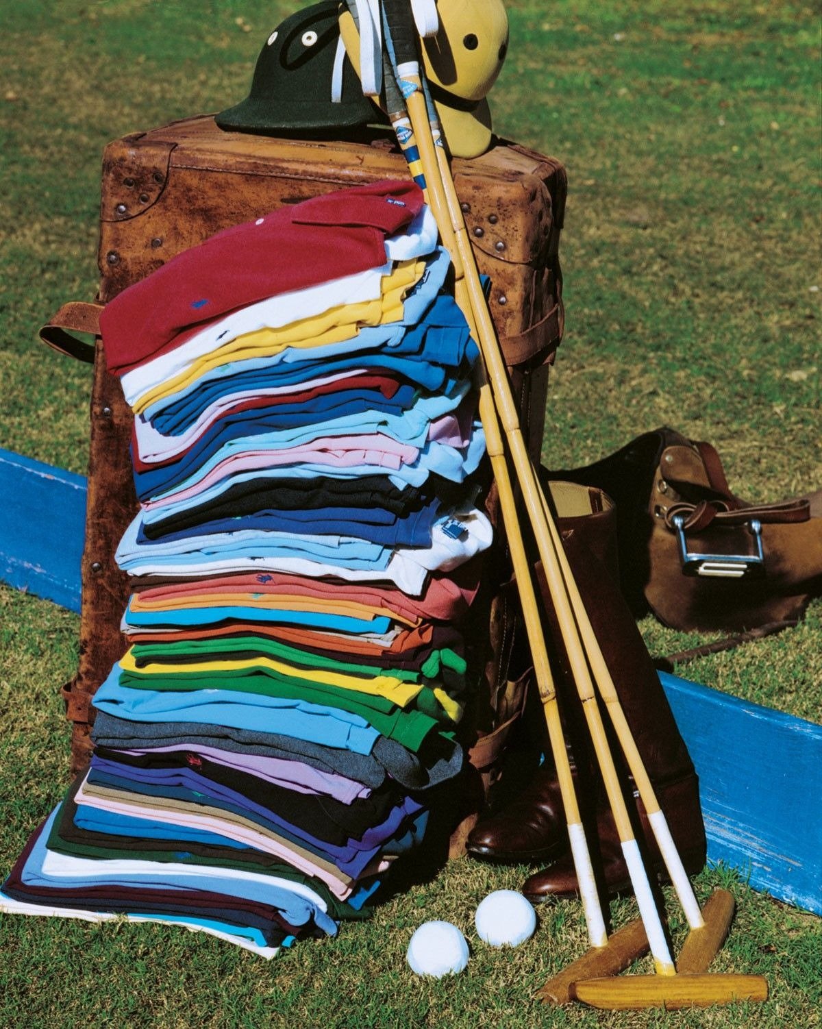 Pilhas coloridas de polos de algodão Ralph Lauren exibem modelagens clássicas sobre mala vintage.