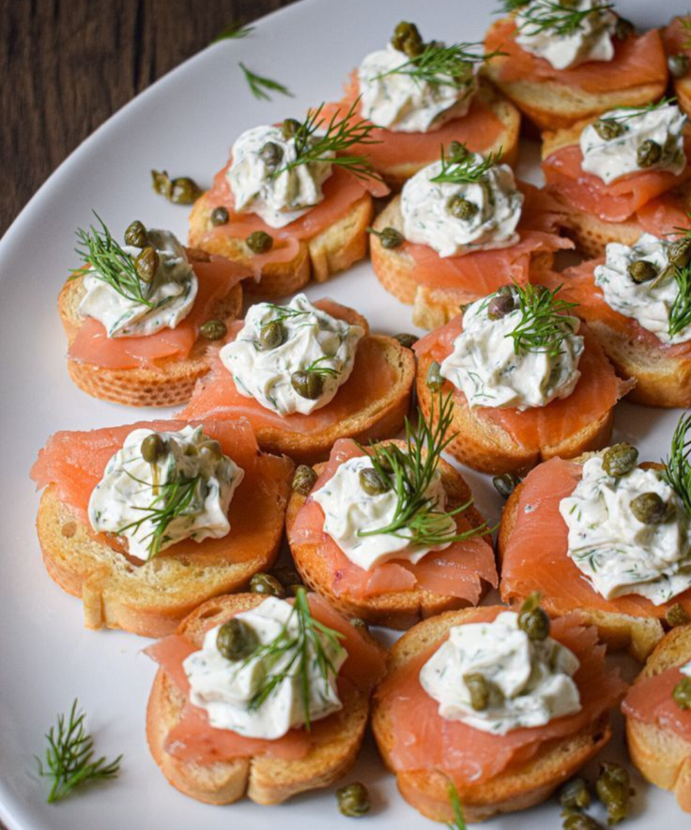 Torradinhas douradas com salmão defumado, creme de ervas, alcaparras e dill frescos compõem receitas para o Ano Novo.