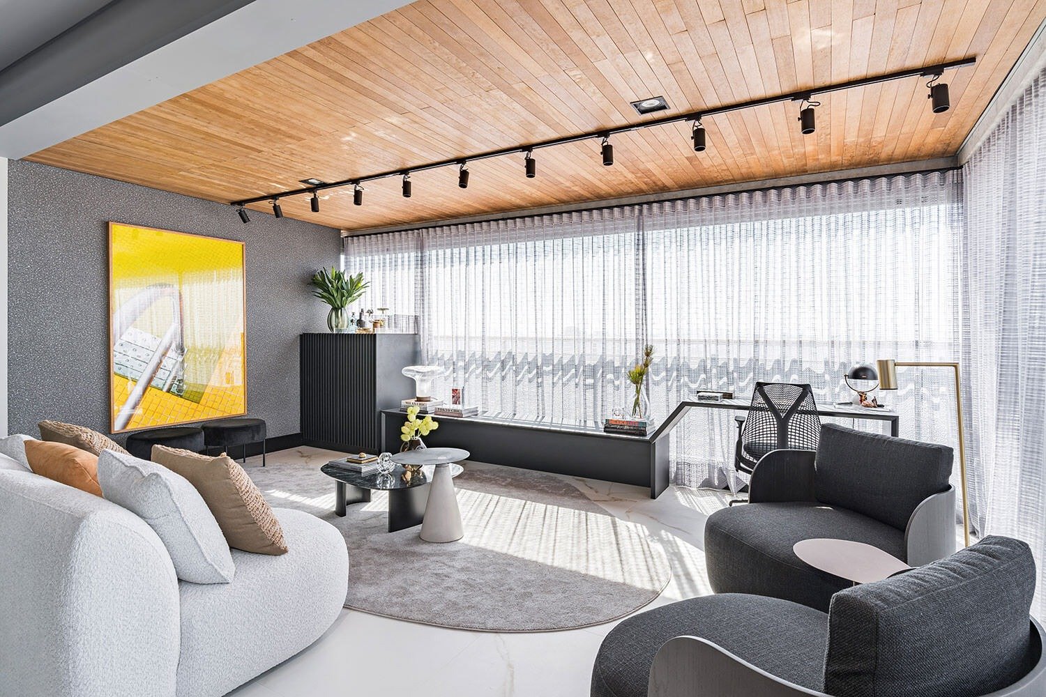 Decoração 2026 aposta em linhas curvas, tons neutros e cinza, madeira no teto e iluminação natural suave para ambiente