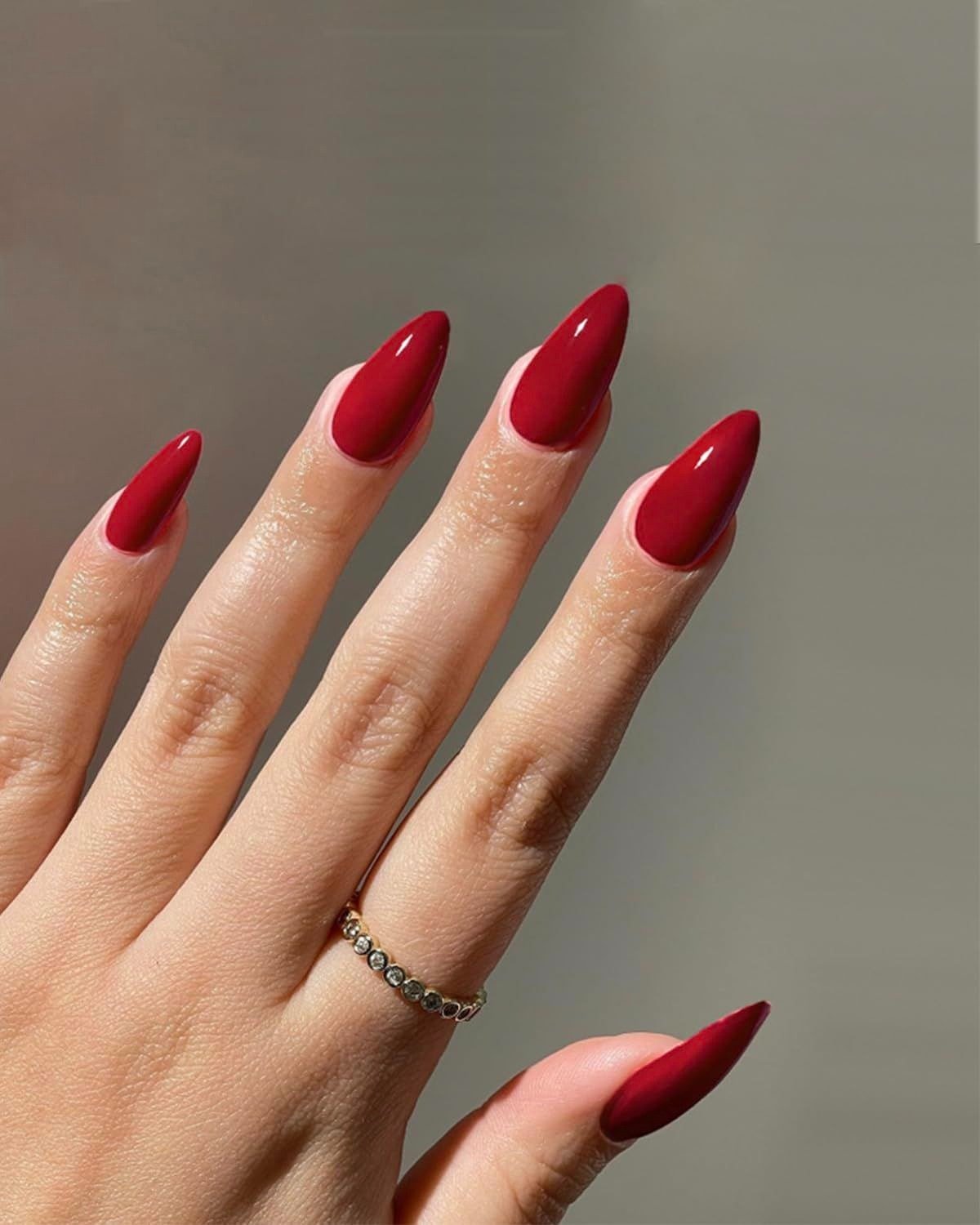 Unhas para Ano Novo com formato amendoado e esmalte vermelho intenso, destacando elegância e sofisticação em clima festivo.