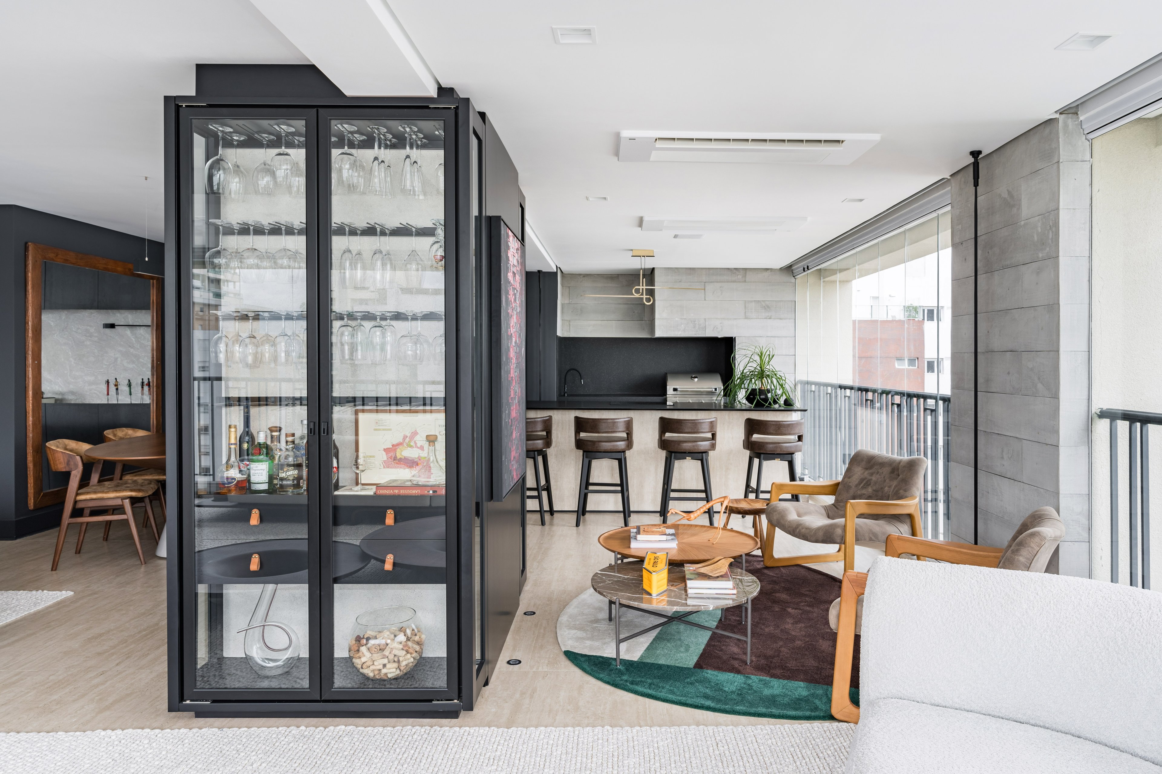 Tendências de arquitetura para cozinha com design integrado, armários escuros, bancada em preto e madeira clara