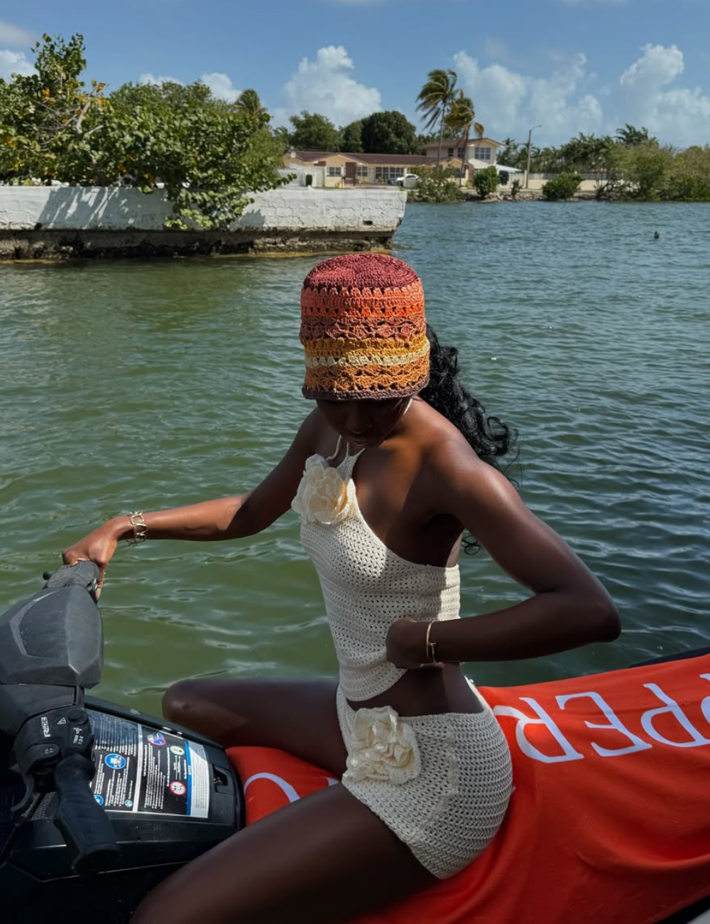 Blusas femininas da moda em crochê off-white com flores 3D, combinadas a chapéu colorido, criam visual artesanal.