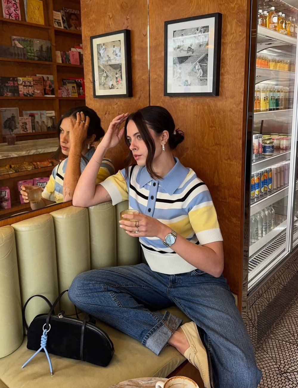 Blusa feminina da moda em tricô com listras azul, amarelo e branco, gola polo e mangas curtas, combinada com jeans.