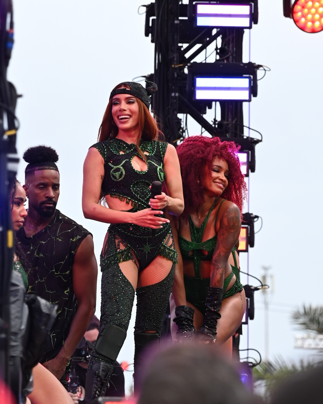 Carnaval 2026 traz looks ousados com body e meia arrastão pretos bordados em verde, modelagens recortadas e atitude vibrante