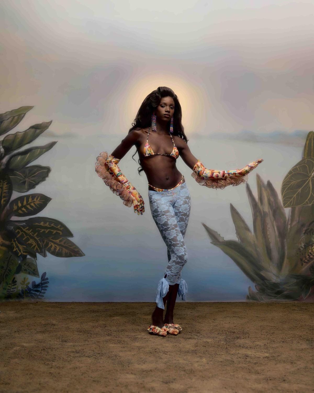 Modelo posa com top de biquíni estampado, calça justa rendada azul clara, celebrando Carnaval 2026