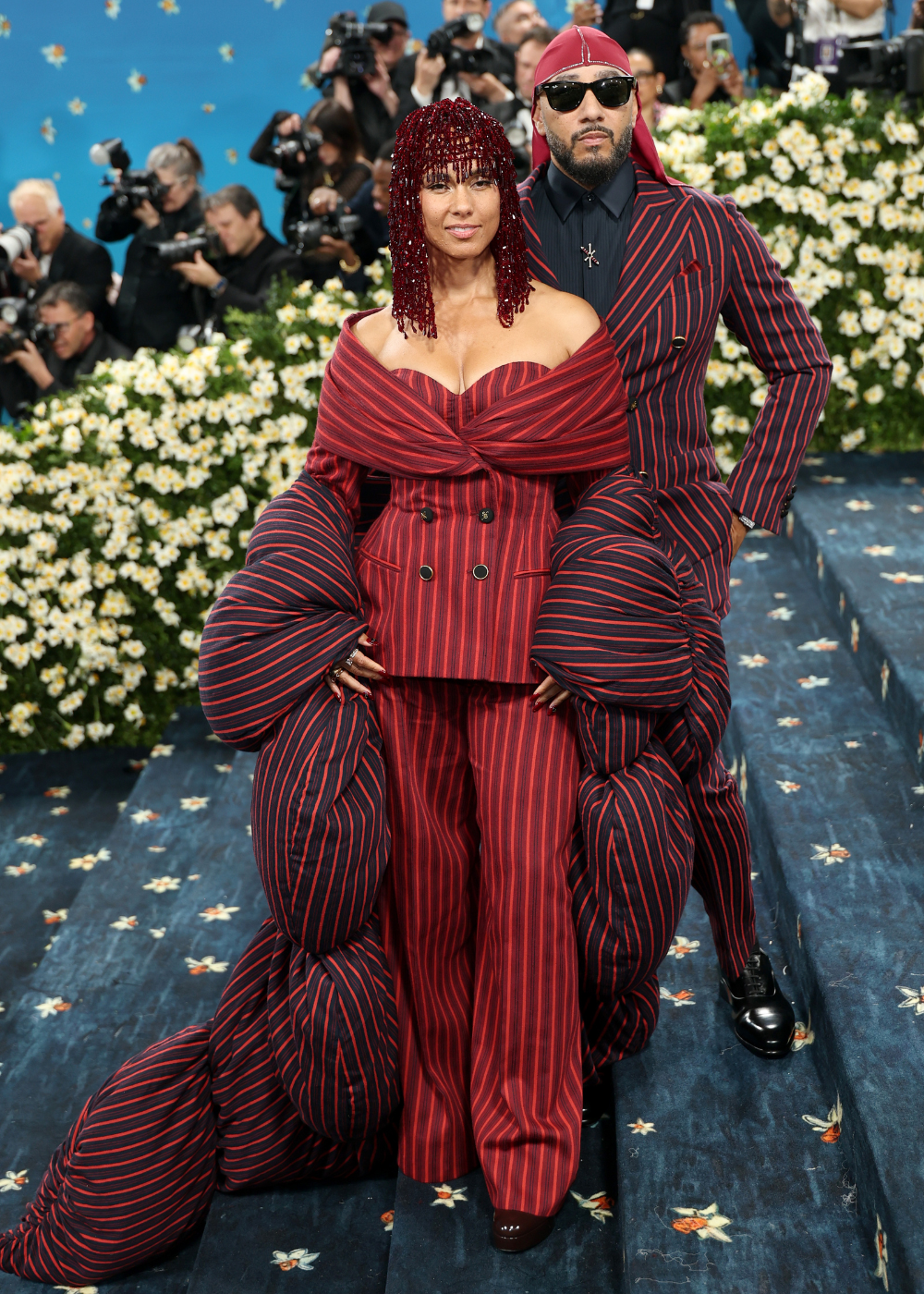 Casal de Hollywood posa com looks listrados em vermelho e preto.