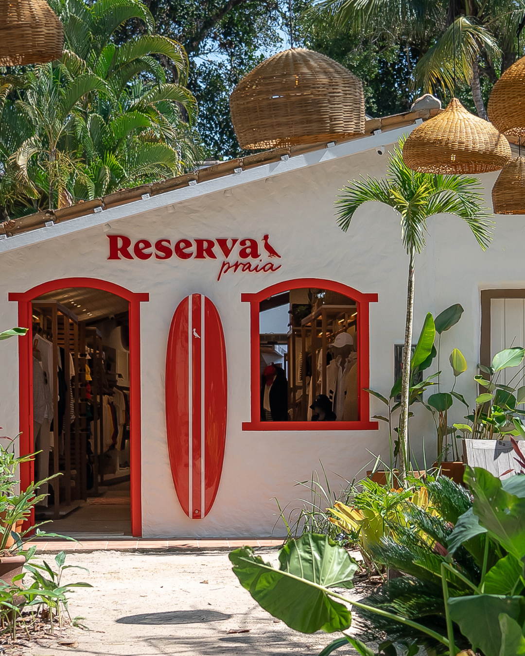 Loja Reserva Praia com detalhes vermelhos, prancha de surf e ambiente tropical que faz parte do guia do verão brasileiro