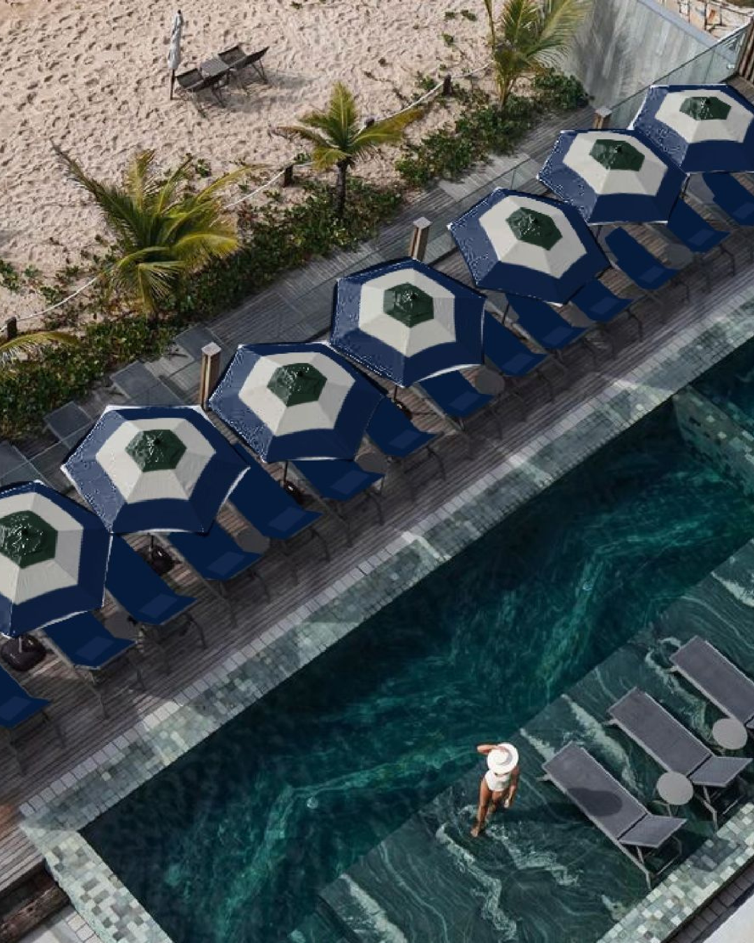 Guia do verão brasileiro com biquíni branco, chapéu de aba larga, piscina de borda infinita e guarda-sóis azul-marinho