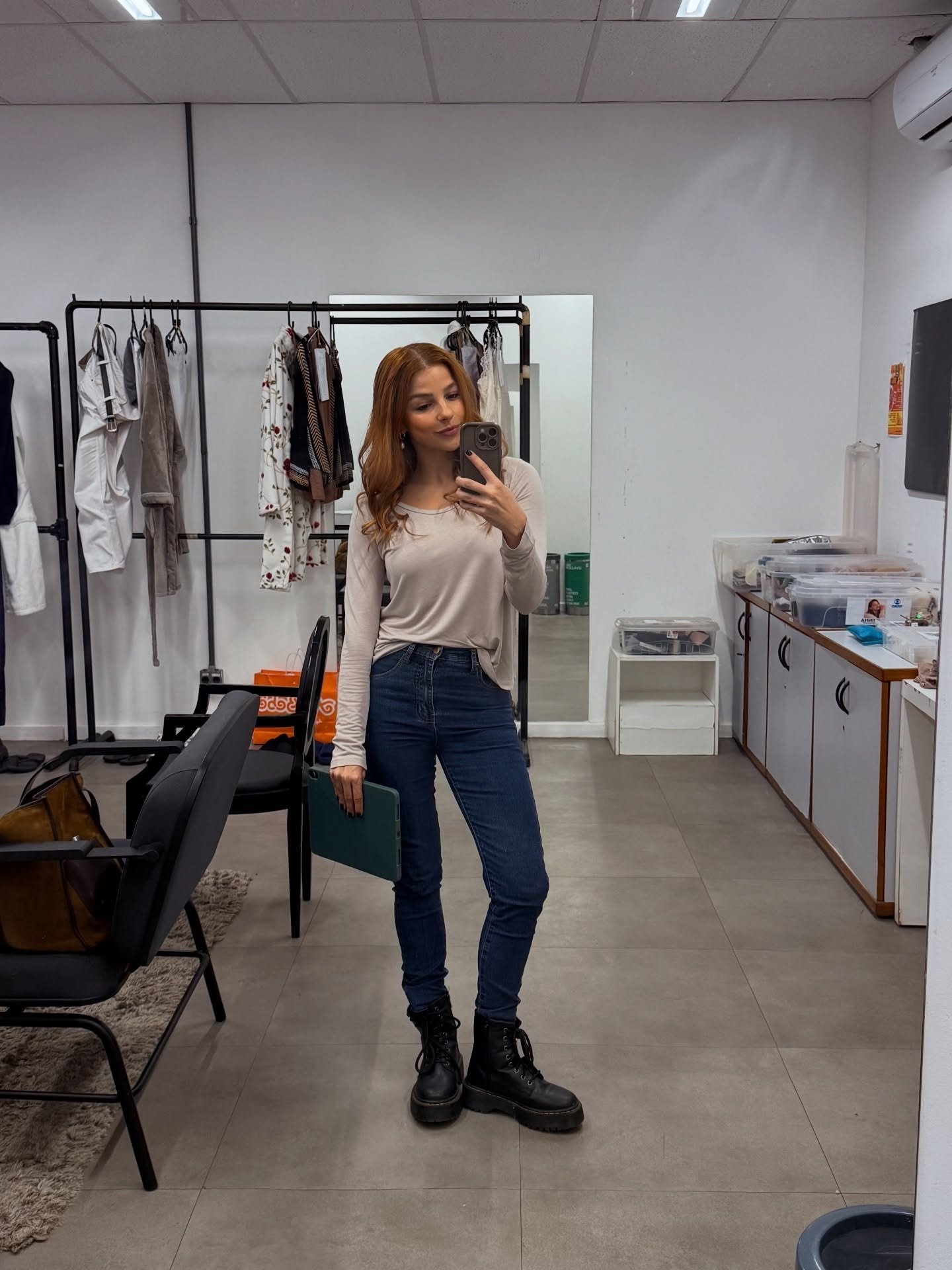 Lorena e Juquinha posam com blusa bege de manga longa, jeans skinny azul e coturno preto, em ambiente minimalista e casual.