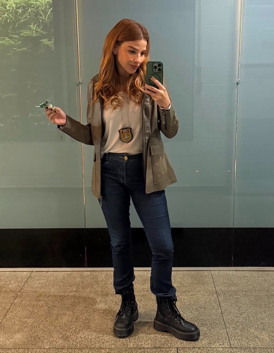 Lorena e Juquinha exibem estilo casual com jaqueta de couro marrom, camiseta clara, jeans escuro e coturno preto, em pose