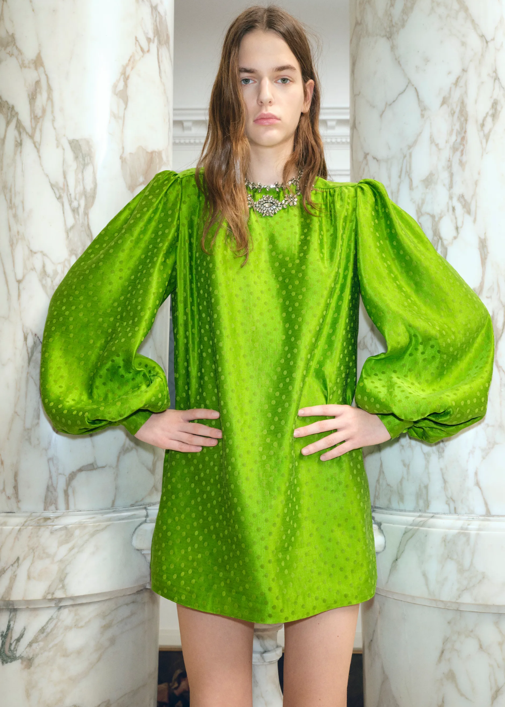 Modelo posa com vestido curto de mangas bufantes verdes.