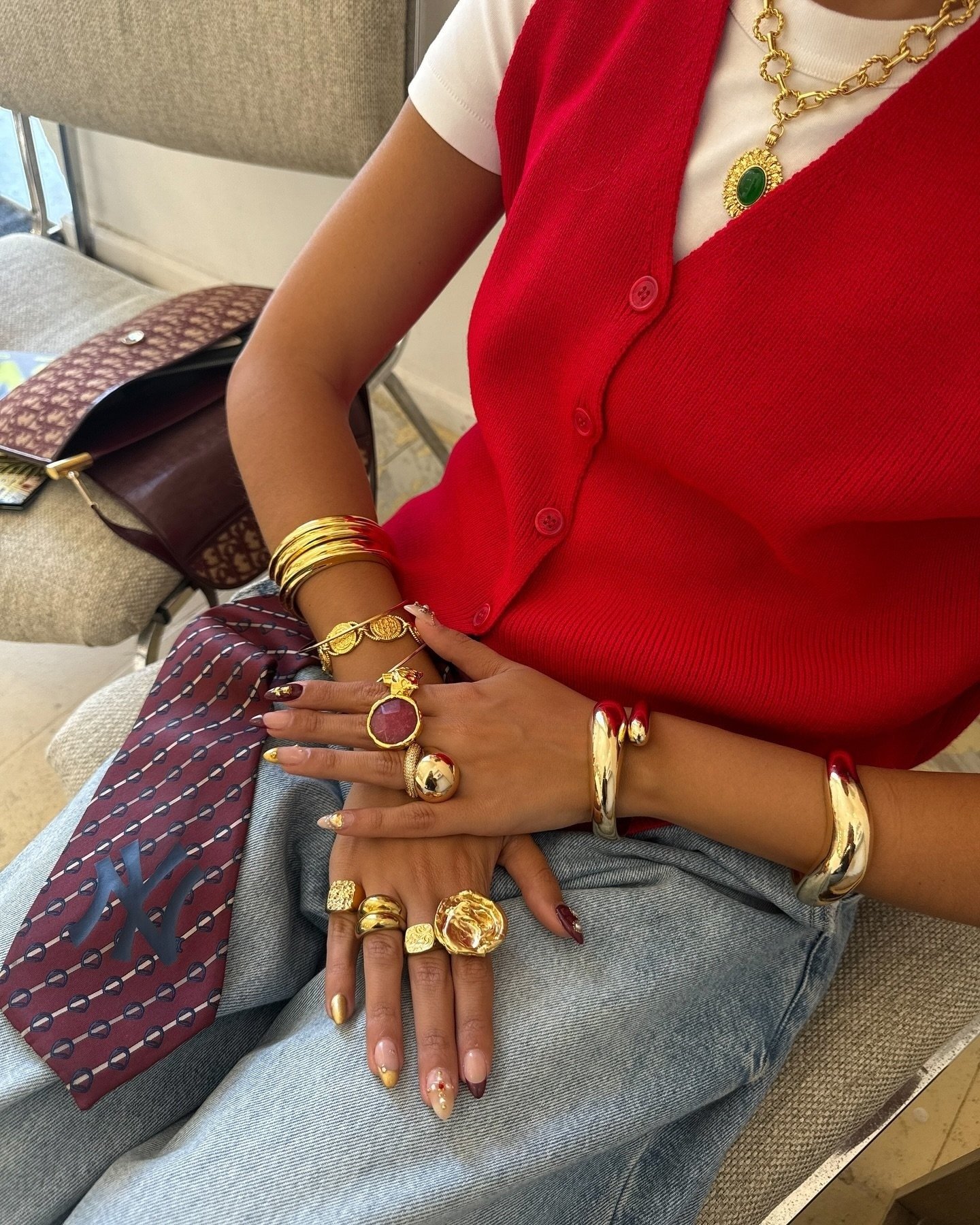 Para o que vestir no calor, combine colete vermelho leve em tricô com camiseta branca e jeans claro, valorizando acessórios