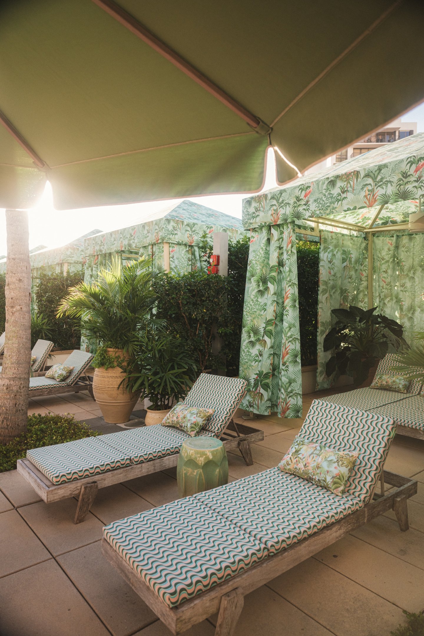 PatBO destaca estilo tropical em cabanas e espreguiçadeiras com estampas verdes e texturas naturais, criando clima relaxante