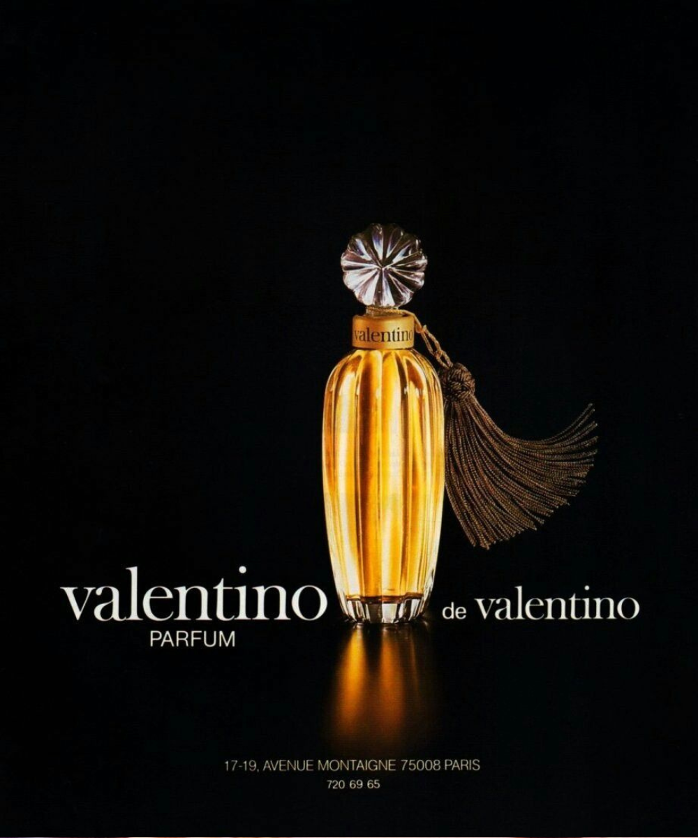 Frasco dourado elegante com tampa facetada e tassel marrom, perfume Valentino destaca luxo clássico e sofisticação atemporal.