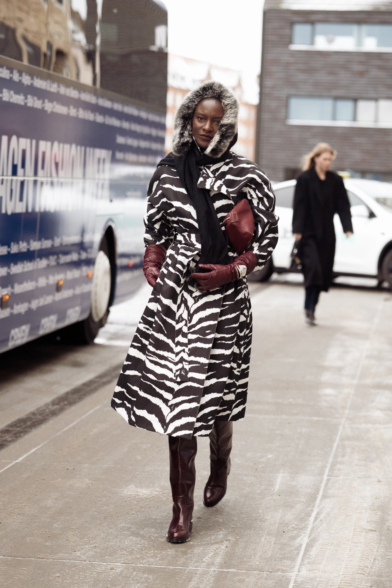 Modelo caminha confiante na Semana de Moda de Copenhagen com casaco animal print preto e branco, capuz peludo