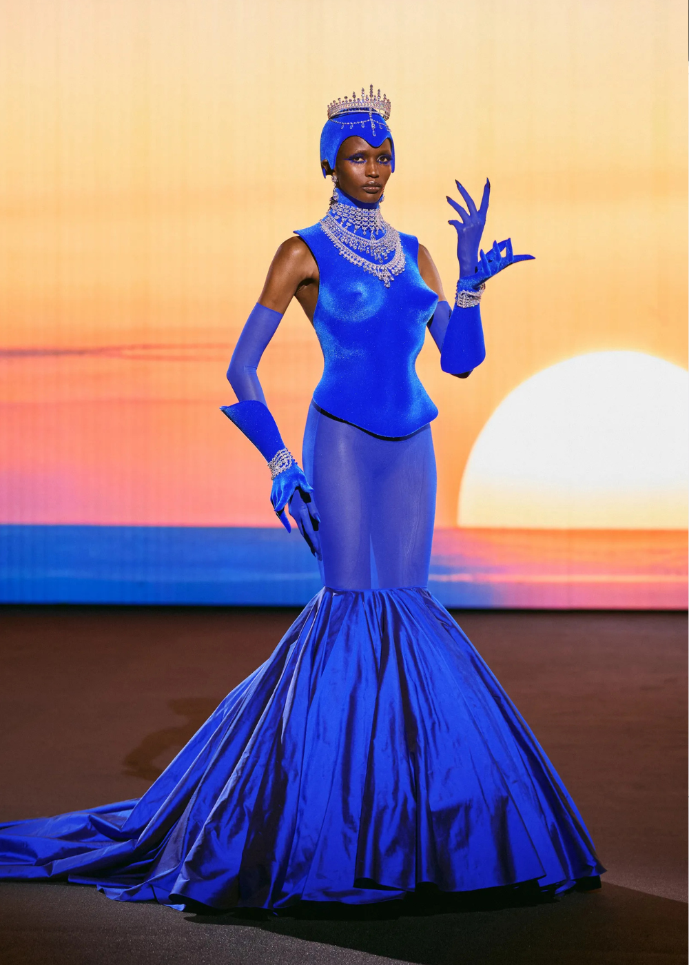 Modelo posa com vestido sereia azul royal de alta-costura primavera 2026, combinando tule, cetim e joias luxuosas que