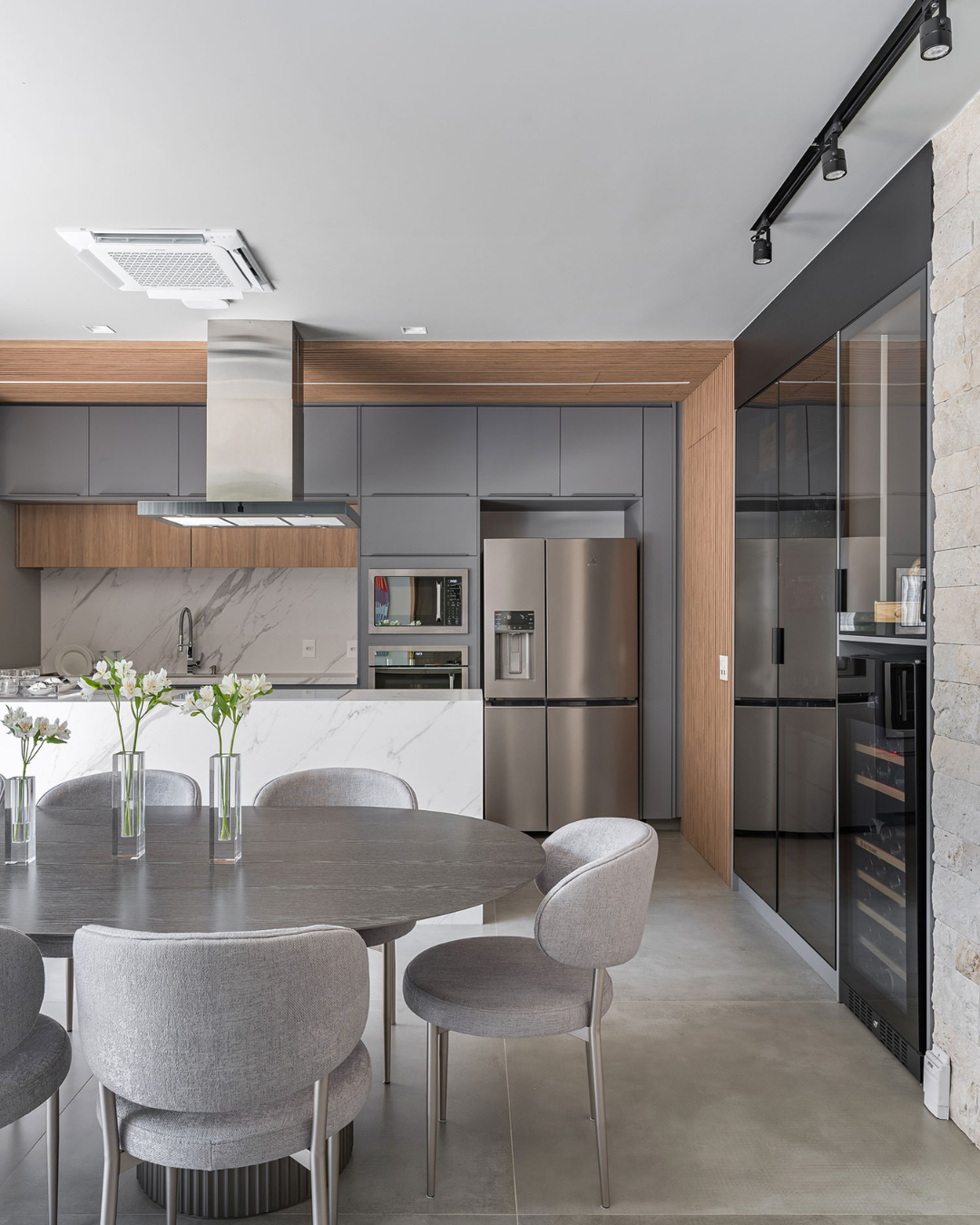 Tendências de arquitetura para cozinha destacam armários cinza fosco, bancada em mármore branco, detalhes em madeira clara e