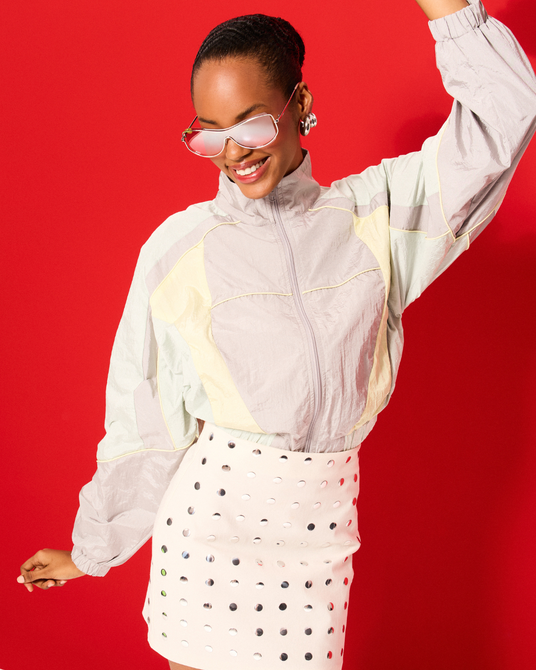 Modelo com tendências de looks para festival, jaqueta nylon oversized em tons pastel e saia branca