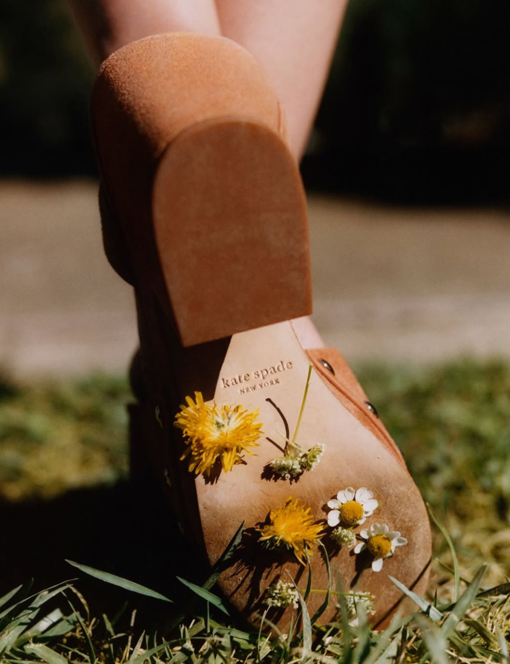 Botina caramelo de couro com sola clara e flores silvestres presas.