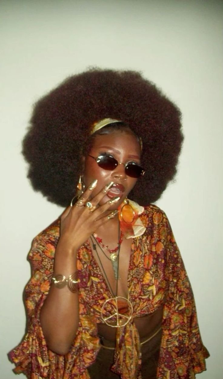 Fantasia de carnaval com blusa estampada floral em tons terrosos, acessórios dourados e óculos escuros