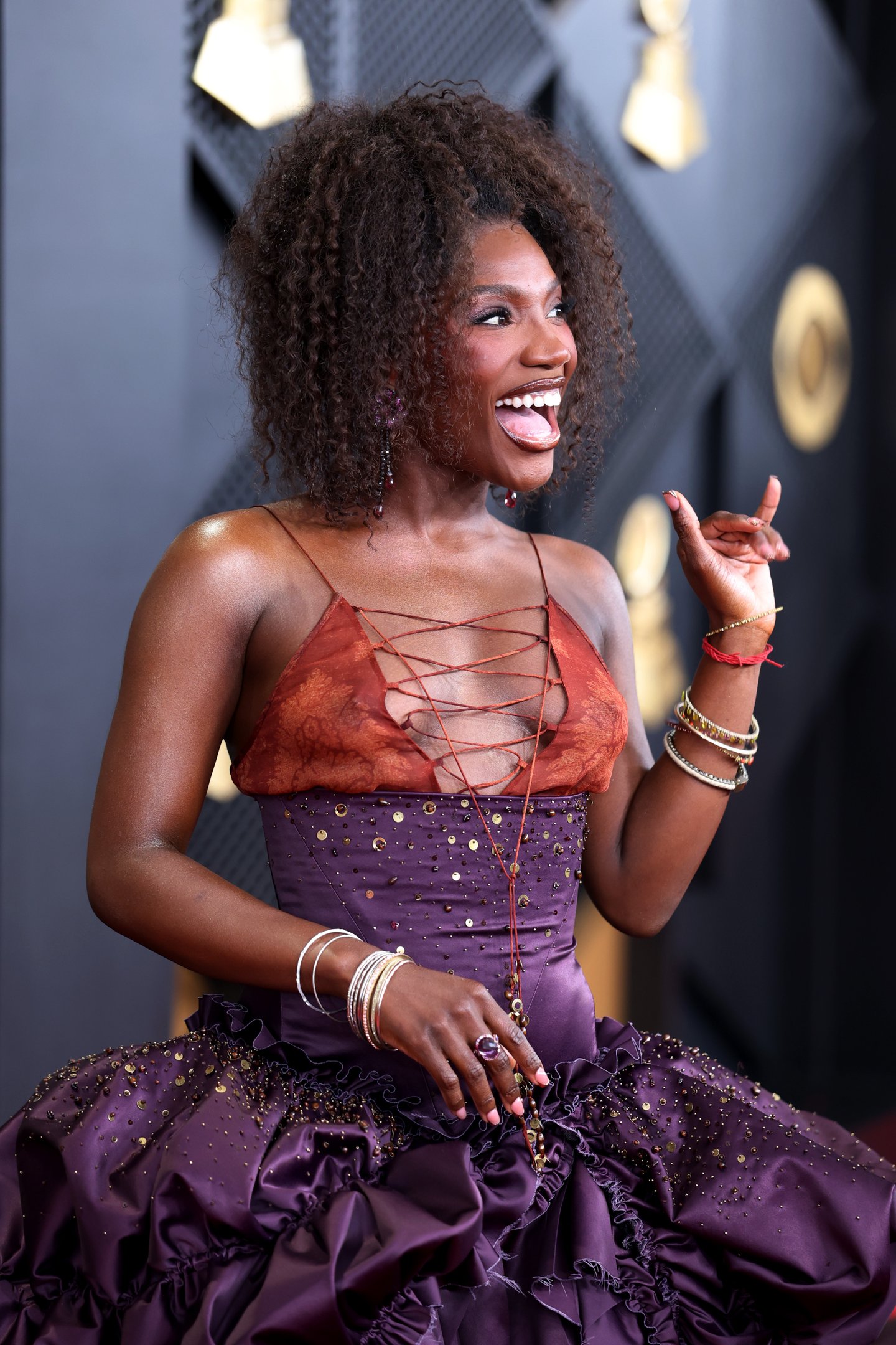 Modelo posa sorrindo com vestido decotado no Grammy 2026.