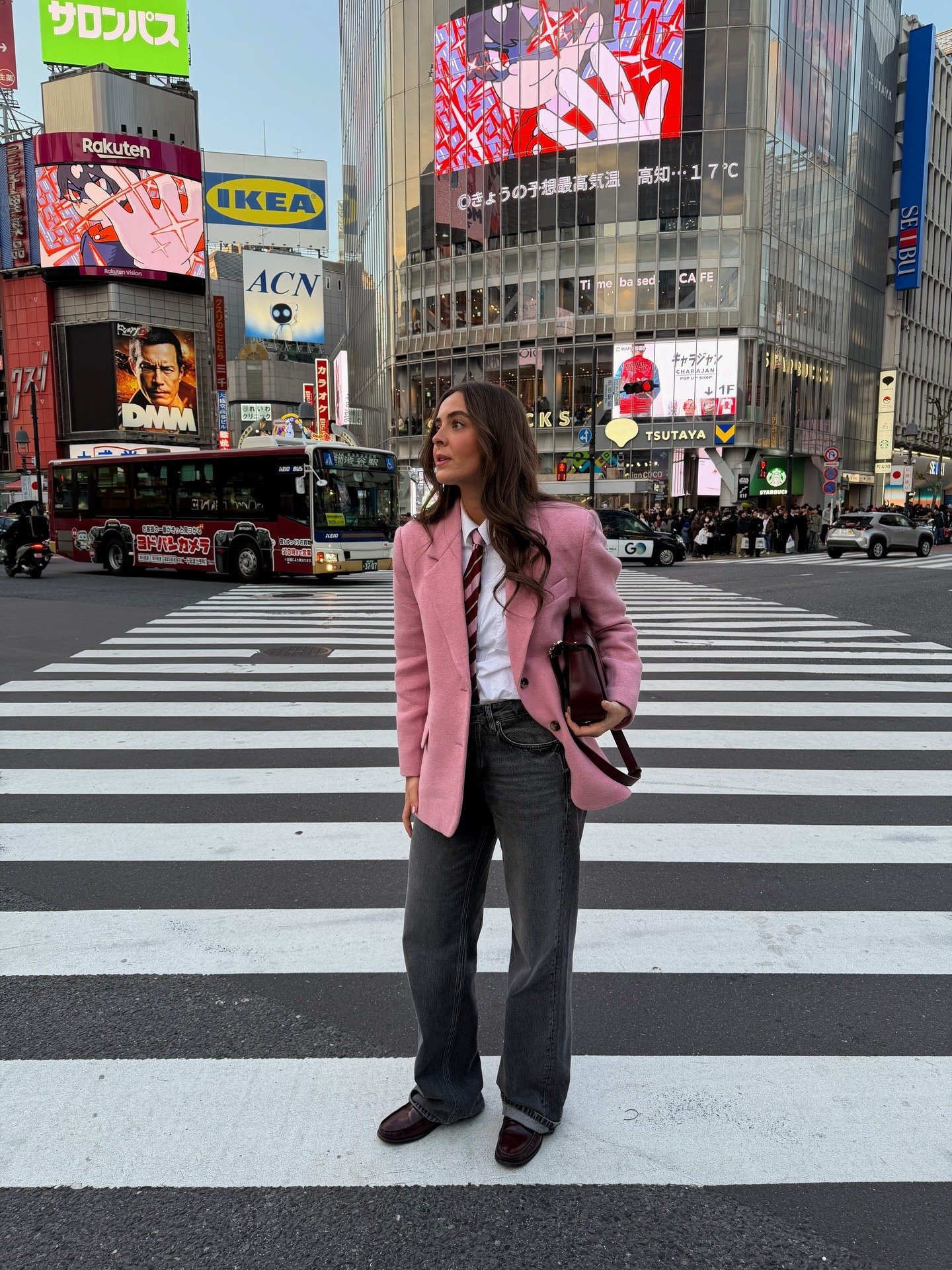 Modelo posa confiante em look esporte fino feminino com calça jeans cinza reta, blazer rosa estruturado, camisa branca