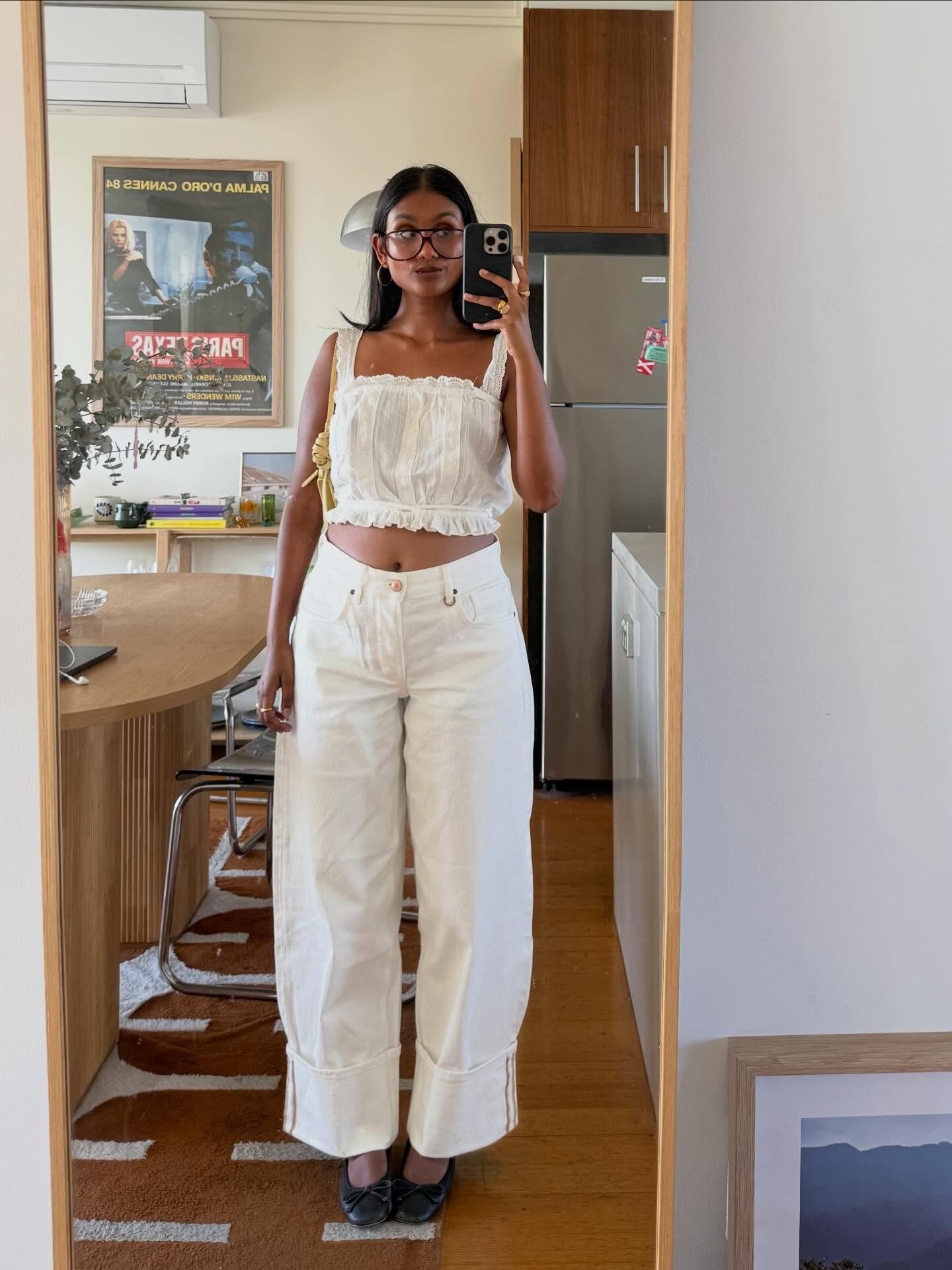 Mulher posa com looks simples e estilosos em cropped branco de algodão com renda e calça jeans ampla off-white
