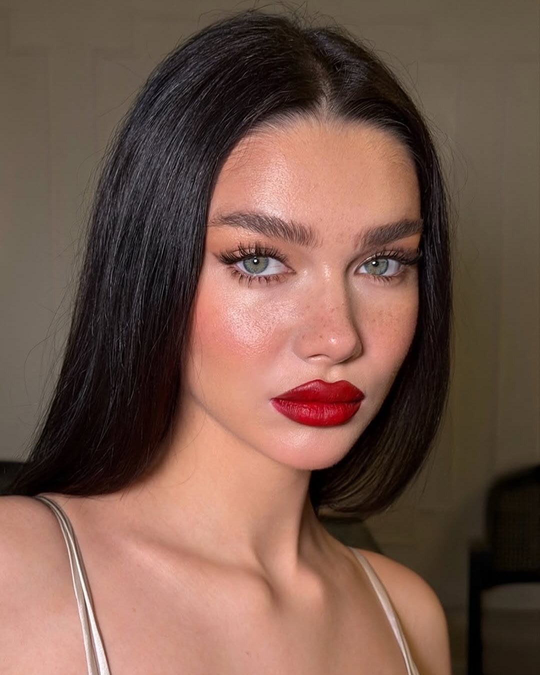 Make de carnaval com batom vermelho vibrante, pele iluminada, cílios longos e olhar intenso, realçando beleza natural