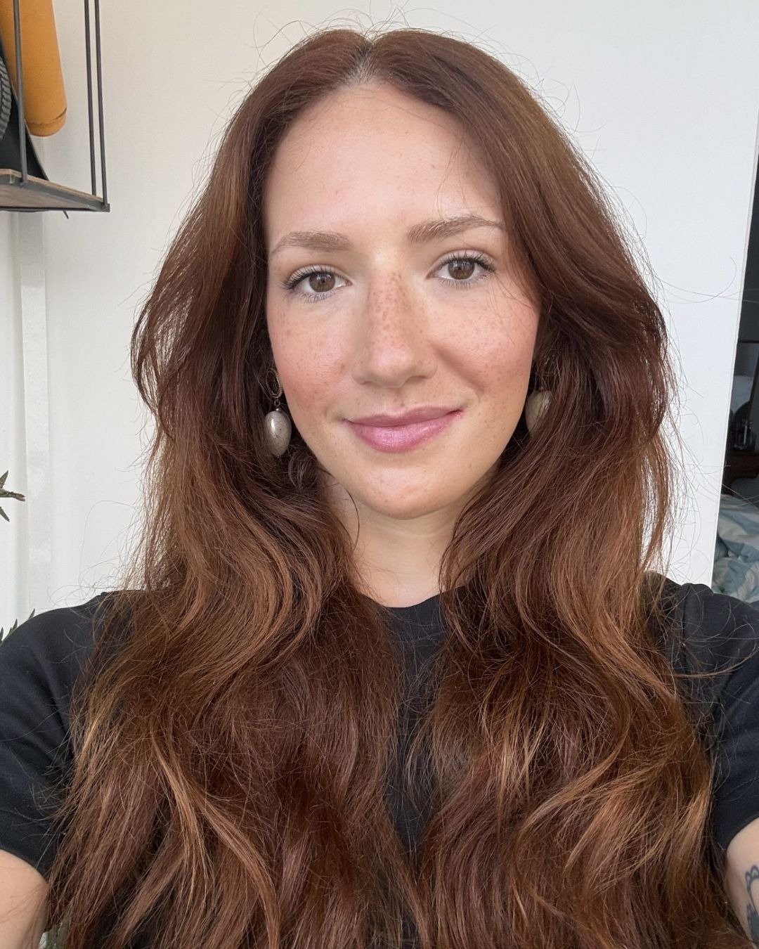 Mulher com cabelo longo e volumoso em tons castanho-avermelhado, sugerindo uso frequente de máscara de reconstrução