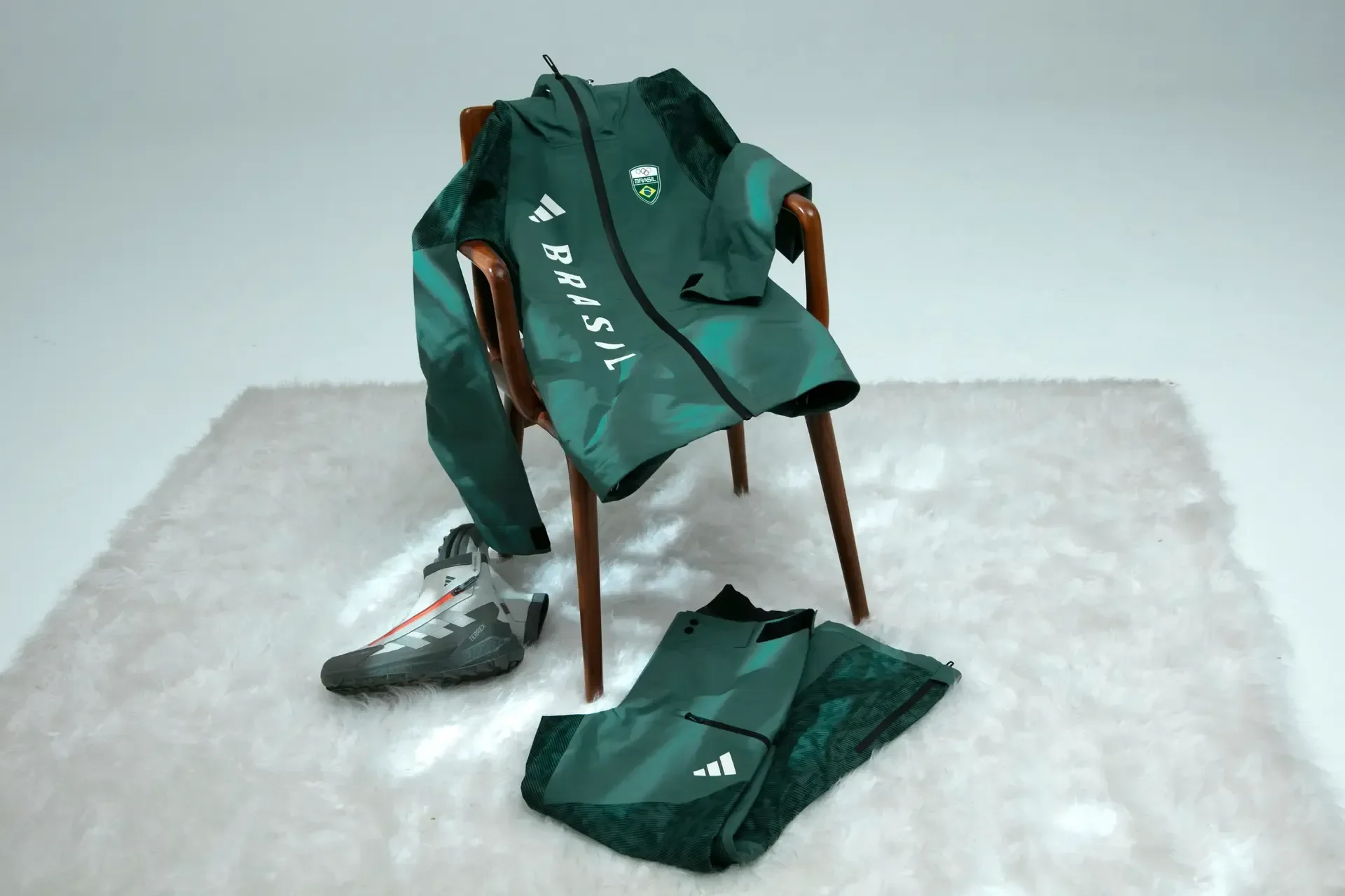 Conjunto esportivo verde com jaqueta e calça em tecido técnico para as Olimpíadas de Inverno 2026, com design moderno