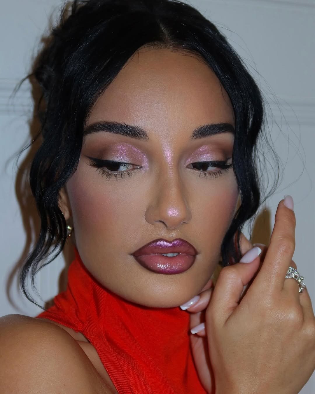 Modelo posa com maquiagem das tendências de maquiagem de 2026, destacando sombra rosada cintilante, delineado preto marcante